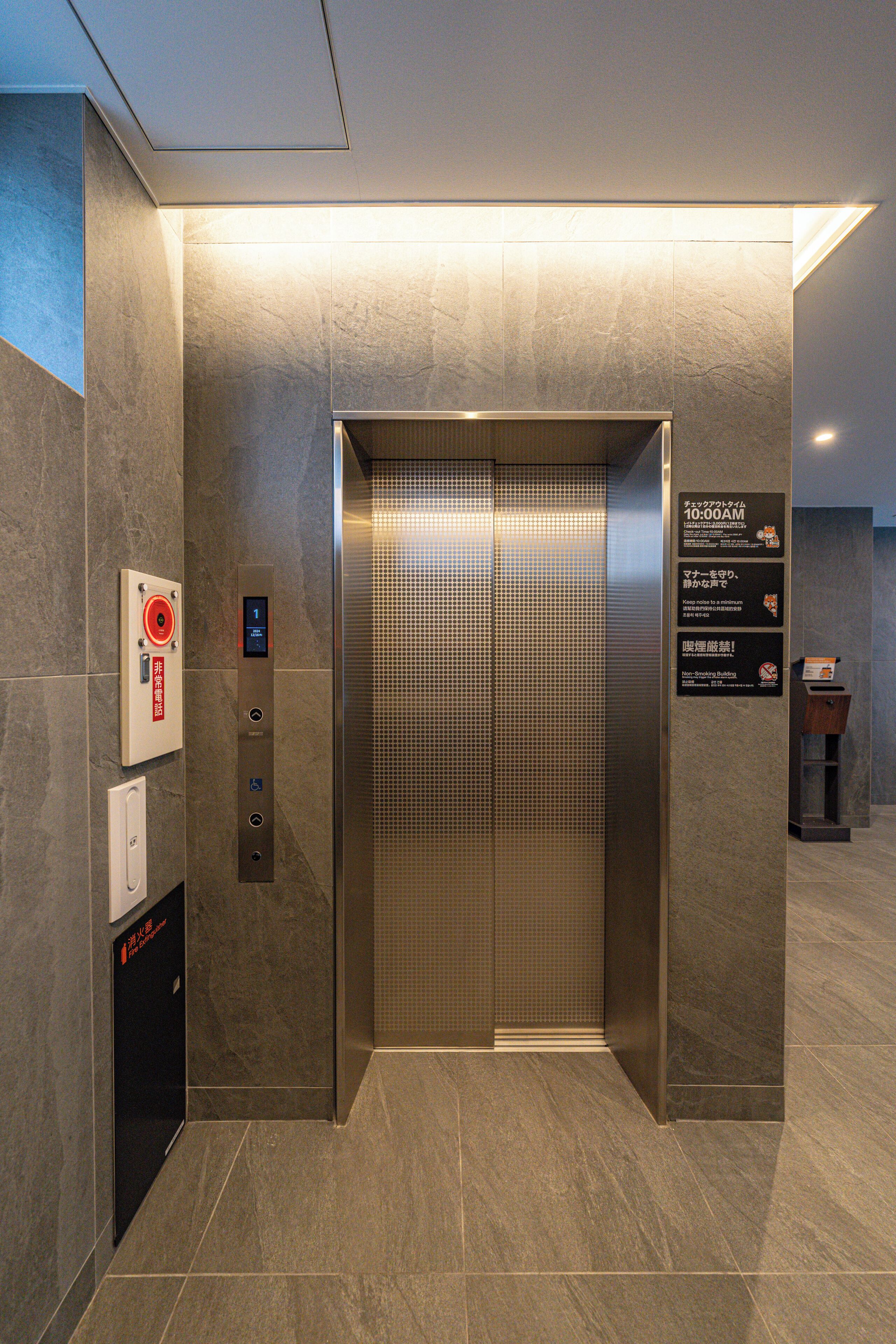 An elevator with a digital display, emergency buttons, and a sign with instructions.