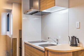 Una cocina moderna con un lavamanos doble, estufa y cafetera.