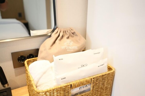 A wicker basket with a drawstring bag and a white item on a hotel room counter. - Its HOTEL (Jeonju)