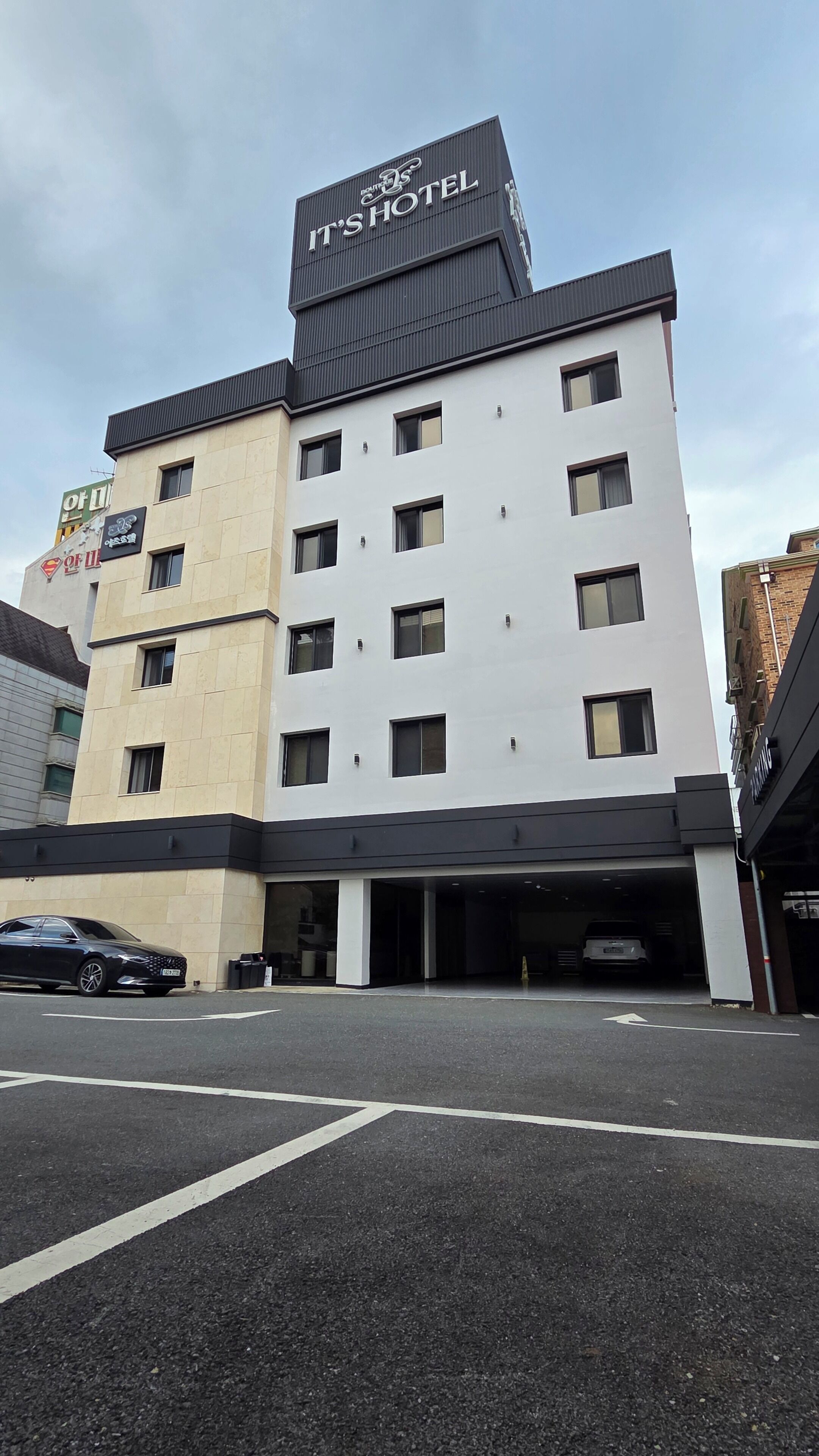 Un hôtel à plusieurs étages, reconnaissable à son grand panneau indiquant : « C’est l’hôtel ».