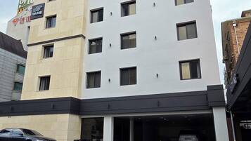 Un hôtel à plusieurs étages, reconnaissable à son grand panneau indiquant : « C’est l’hôtel ».
