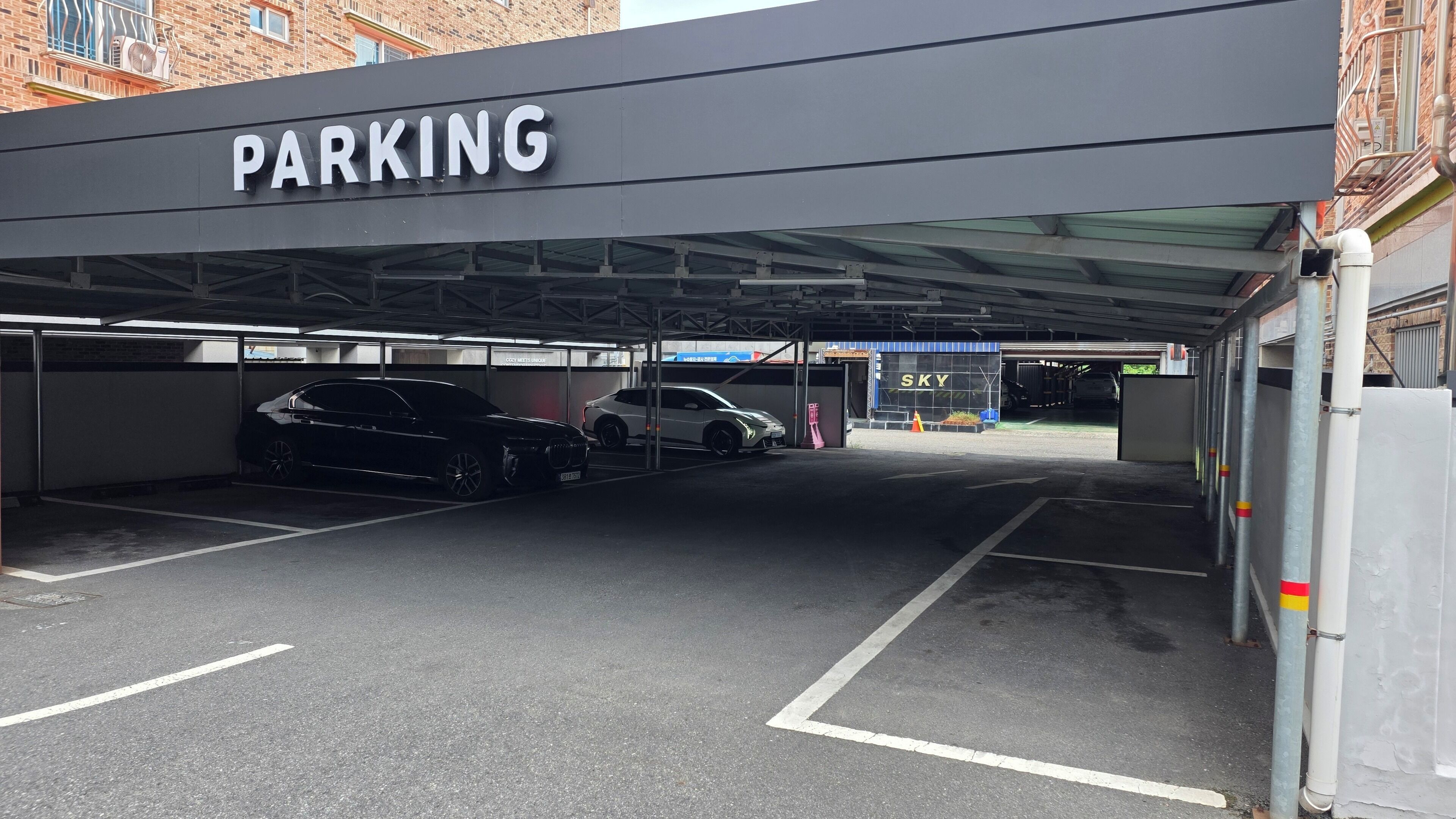 A parking garage with a 'PARKING' sign overhead.