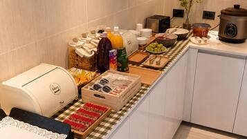 A breakfast buffet setup with various food items and a slow cooker on the counter.
