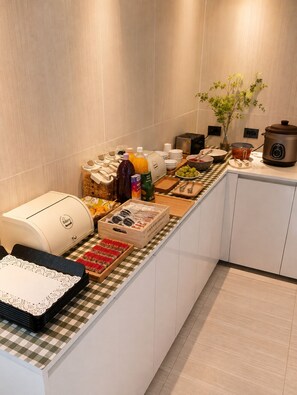 A breakfast buffet setup with various food items and a slow cooker on the counter. - Its HOTEL (Jeonju)