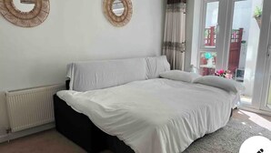 A bedroom with a bed, a radiator, and a view of the outside. - Town center white house (Bournemouth)