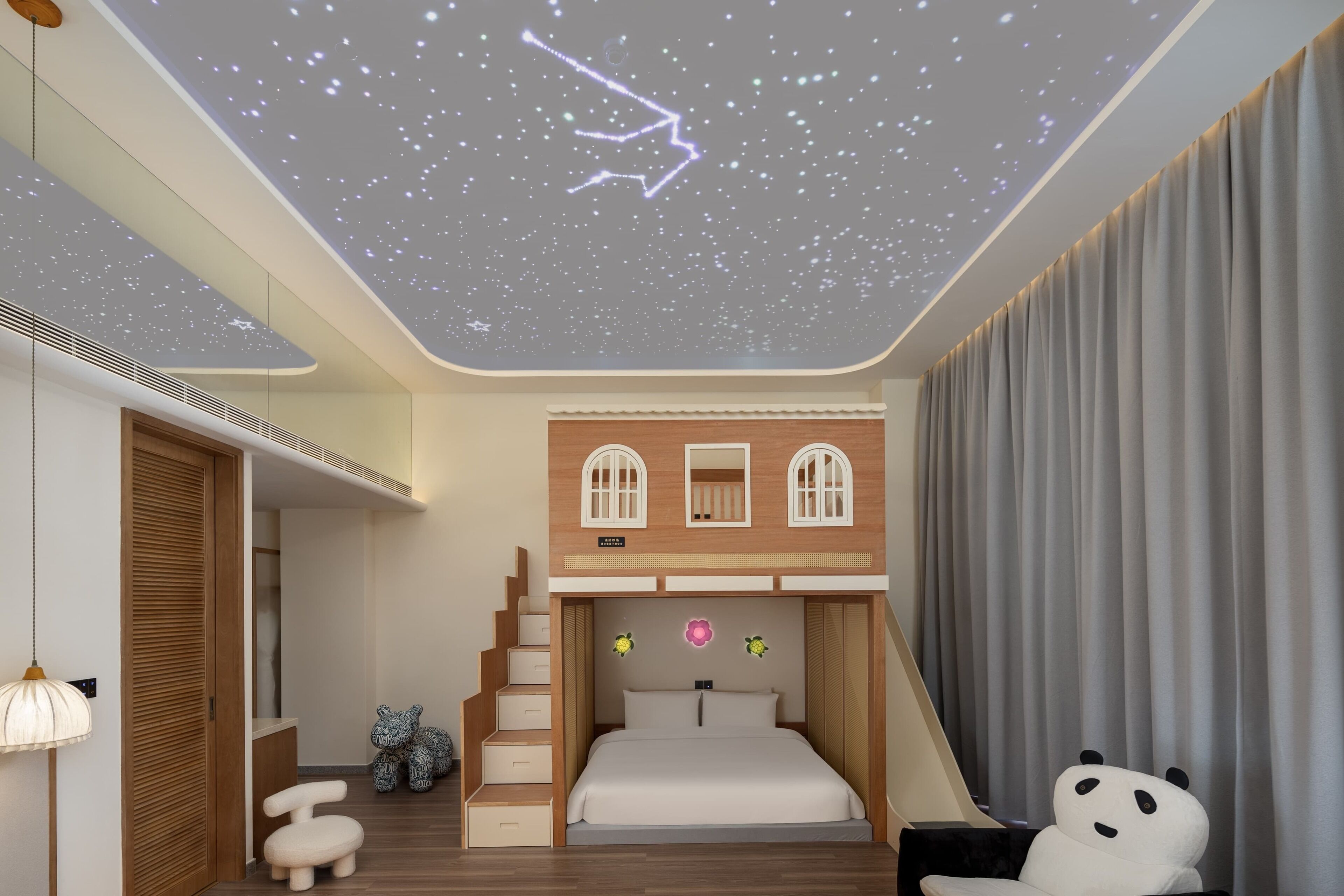 A bedroom with a starry ceiling, a bed, a staircase, and a panda chair.