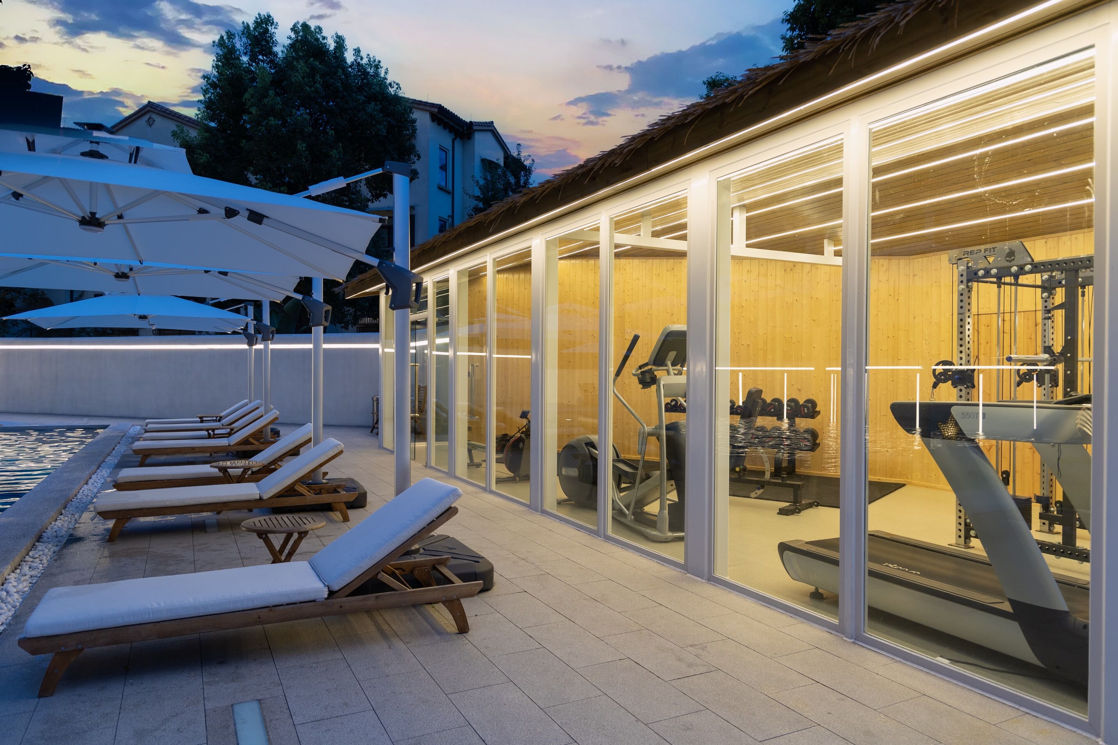 A rooftop lounge area with sun loungers and exercise equipment.