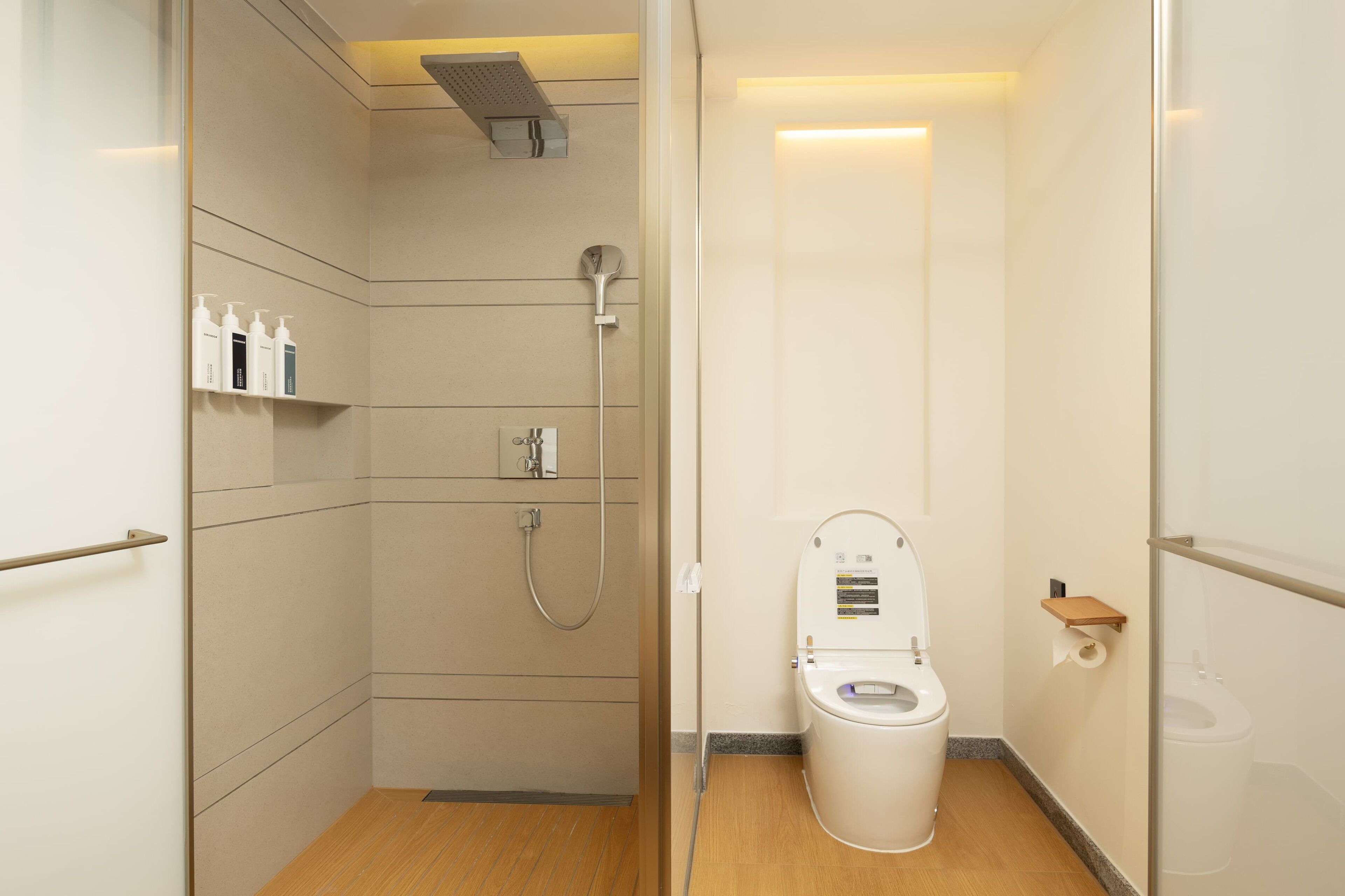 A compact bathroom with a shower, toilet, and storage shelves.