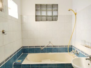 A bathroom with a bathtub, a sink, and a shower. - Homestay Famili Taqwa (Jakarta)
