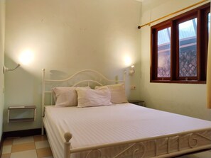A bedroom with a bed, bedside tables, and a window. - Homestay Famili Taqwa (Jakarta)