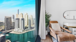 A modern living room with a view of a city skyline and a body of water. - EDEN’S Homes & Villas - VIDA Dubai Marina Residences (Dubai)
