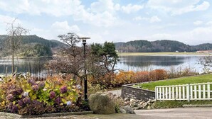 A lakeside view with a stone pathway, a white fence, and a lamp post. - 5 Star Holiday Home in Uddevalla (Uddevalla)