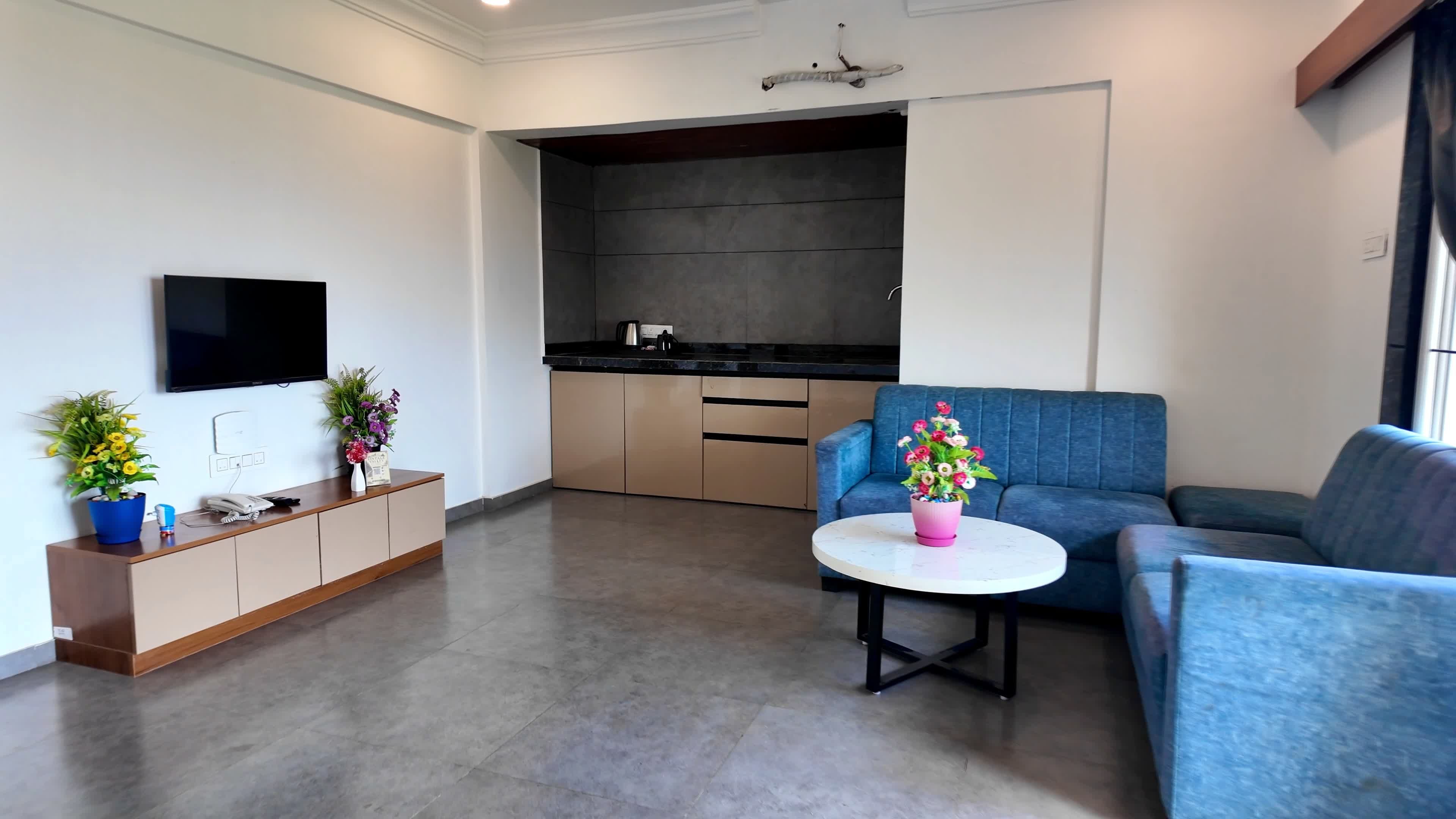 Una sala de estar moderna con un sofá, una mesa de centro y un televisor montado en la pared.