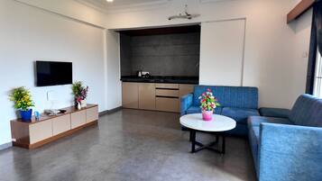 Una sala de estar moderna con un sofá, una mesa de centro y un televisor montado en la pared.