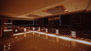 A modern bar area with a reflective floor, geometric patterned wall designs, and recessed lighting. - Hotel Guru Kripa, Bhopal (Bhopal)