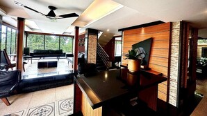 A modern interior with a kitchen area, a dining space with a sofa, and a staircase leading to another level.