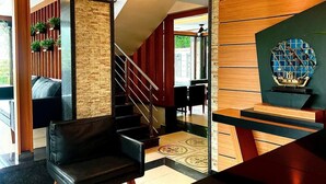A modern interior with a staircase, a seating area, and a decorative wall.