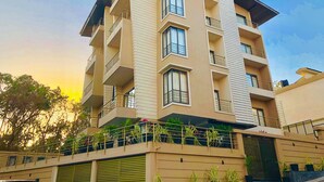 A multi-story building with balconies, large windows, and a flat roof.