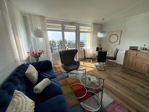 Relax in this stylish living room with a sofa, armchair, and coffee table, offering a view of the outdoors.