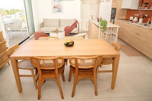 Relax in this inviting space with a central dining table, comfortable sofa, and a kitchen area.