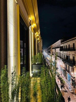 Vista notturna di un edificio con un balcone che si affaccia su una strada.