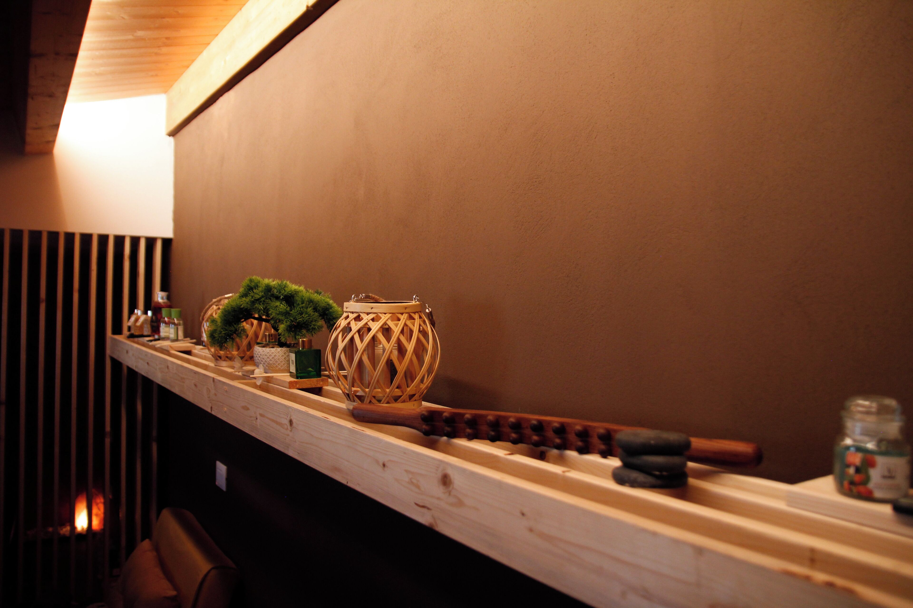 A wooden bar counter with a woven basket, a small plant, and a candle holder.