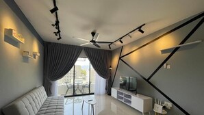 Una sala de estar moderna con un sofá, un mueble para televisión y un ventilador de techo.