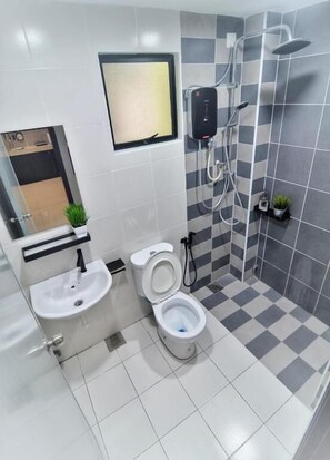 Un baño moderno con inodoro, lavamanos y ducha.