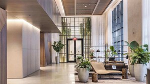 A modern lobby with a reception desk, seating area, and large windows. - Stylish 2BR with Pool & Balcony (Miami)