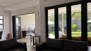 Una sala de estar moderna con un ventanal que da a un patio.
