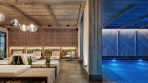 A modern indoor pool area with wooden beams, lounge seating, and patterned walls. - Wulfenia Hotel & Spa (Kolašin)