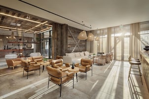 A spacious lobby with leather sofas, a coffee table, and pendant lighting.