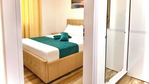 Una camera da letto con un letto, un armadio e un quadro appeso al muro.