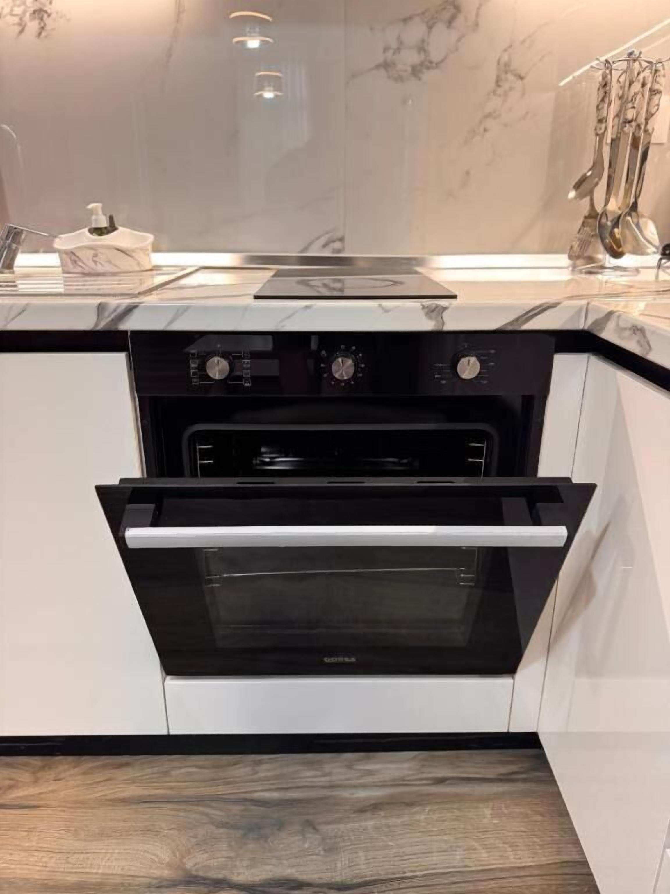 A kitchen with a built-in oven, a microwave, and a stovetop.