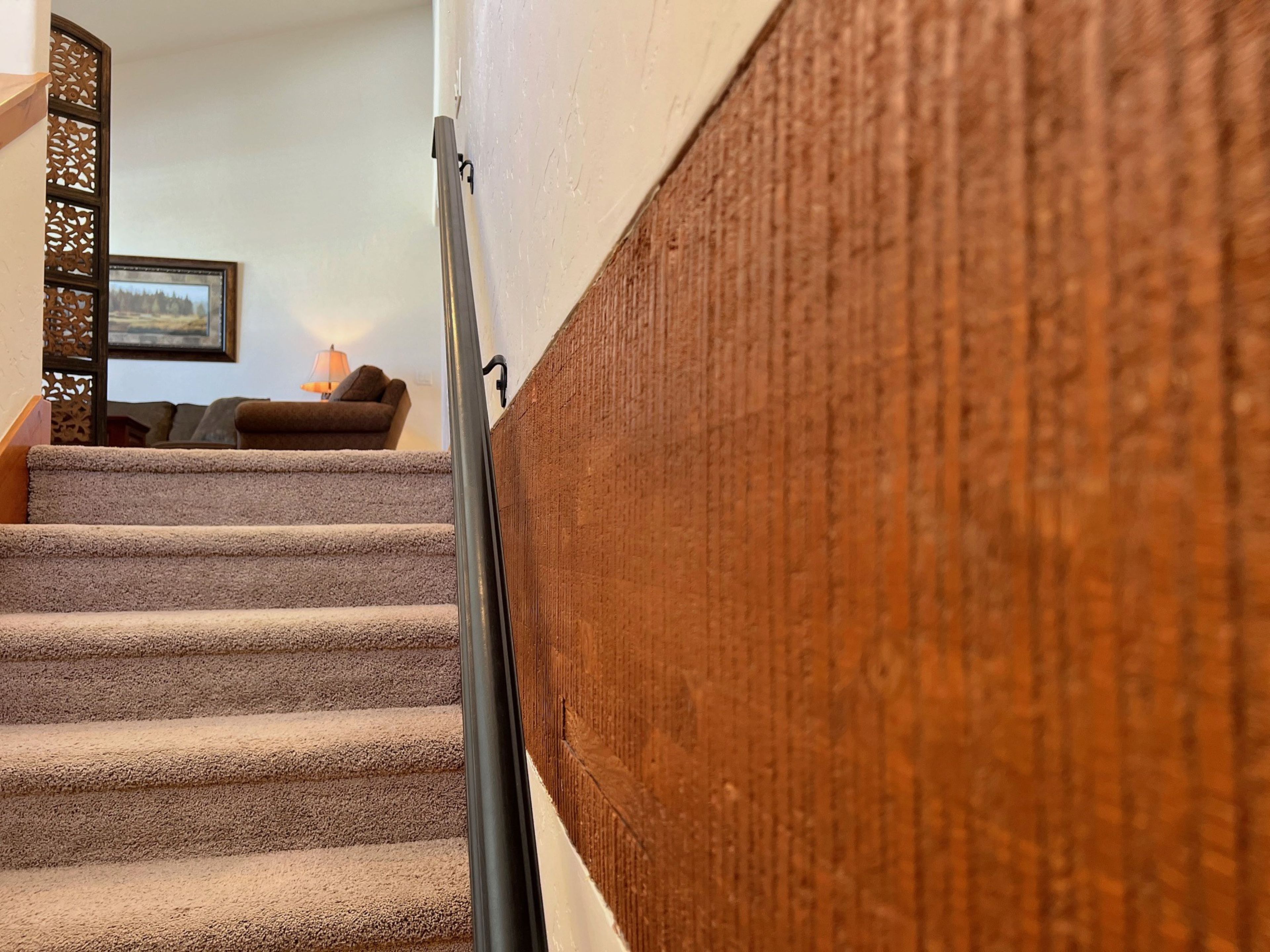 A staircase with carpeted steps leading to a landing.