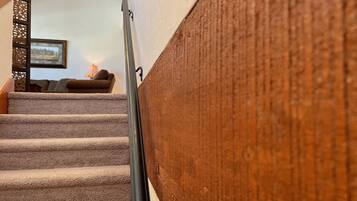 A staircase with carpeted steps leading to a landing.