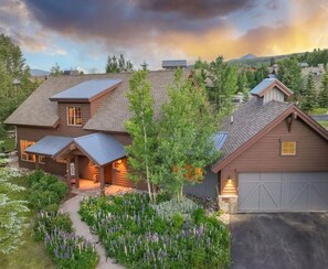 A two-story house with a garage, solar panels, and a well-maintained garden.