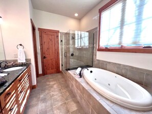 A bathroom with a glass-enclosed shower, a freestanding bathtub, and a wooden door. - Eagles Nest • Mtn Views • Dog-Friendly • Ev Charger • Ski/Hike (Silverthorne)