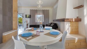 A dining area with a round table, white chairs, and blue plates. - 4204 Villetta Delle More by Barbarhouse (Melendugno)