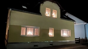 A two-story building with a green facade and multiple windows.