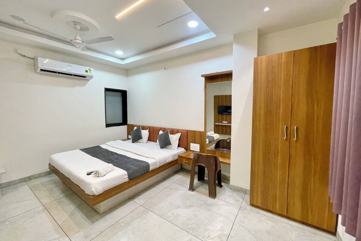 Ein modernes Schlafzimmer mit einem großen Bett, einem Holzschrank, einem Spiegel und einem Deckenventilator.