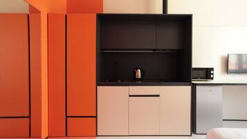 A modern kitchen with a black countertop, a coffee maker, and a microwave.