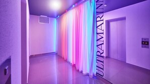 A hallway with a series of curtains and a sign that reads "ULTRAMARINN." - Ultramarinn Hotel (Odesa)