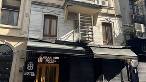 Um hotel com toldo preto e uma placa com a inscrição 'GRAN BRN HOTEL'.