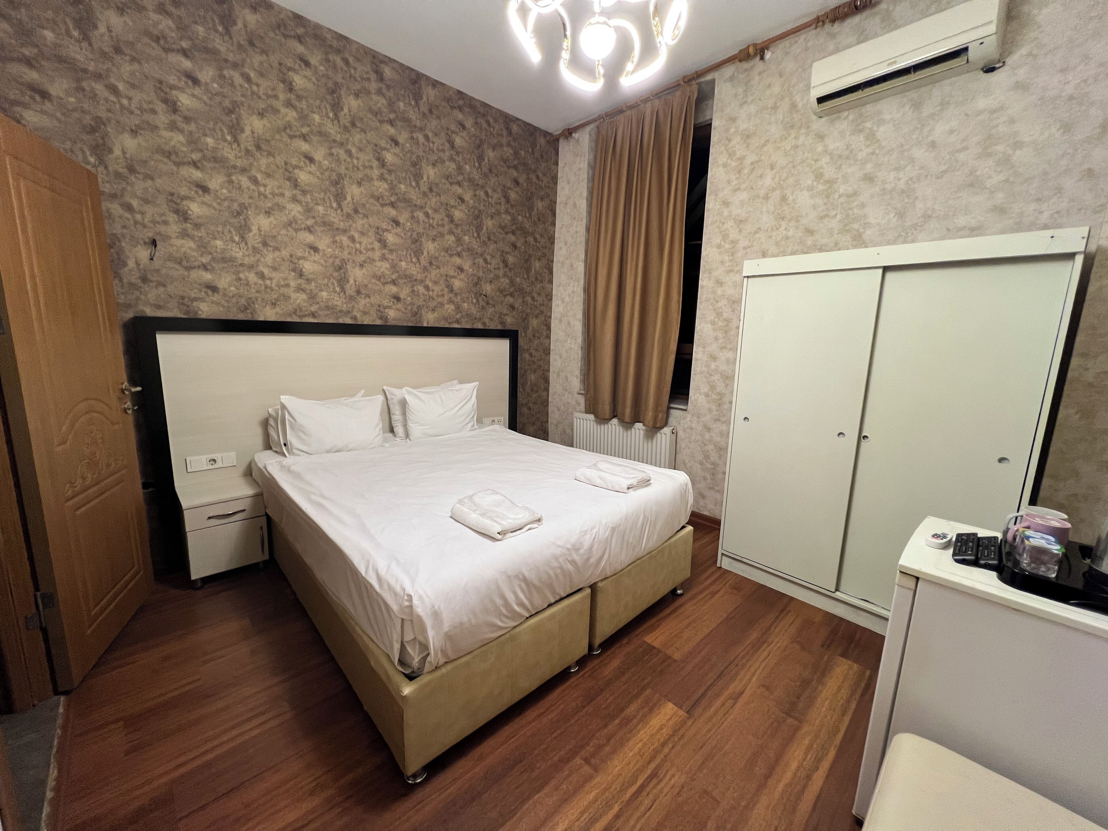 A bedroom with a bed, bedside tables, a wardrobe, and a desk with a chair.