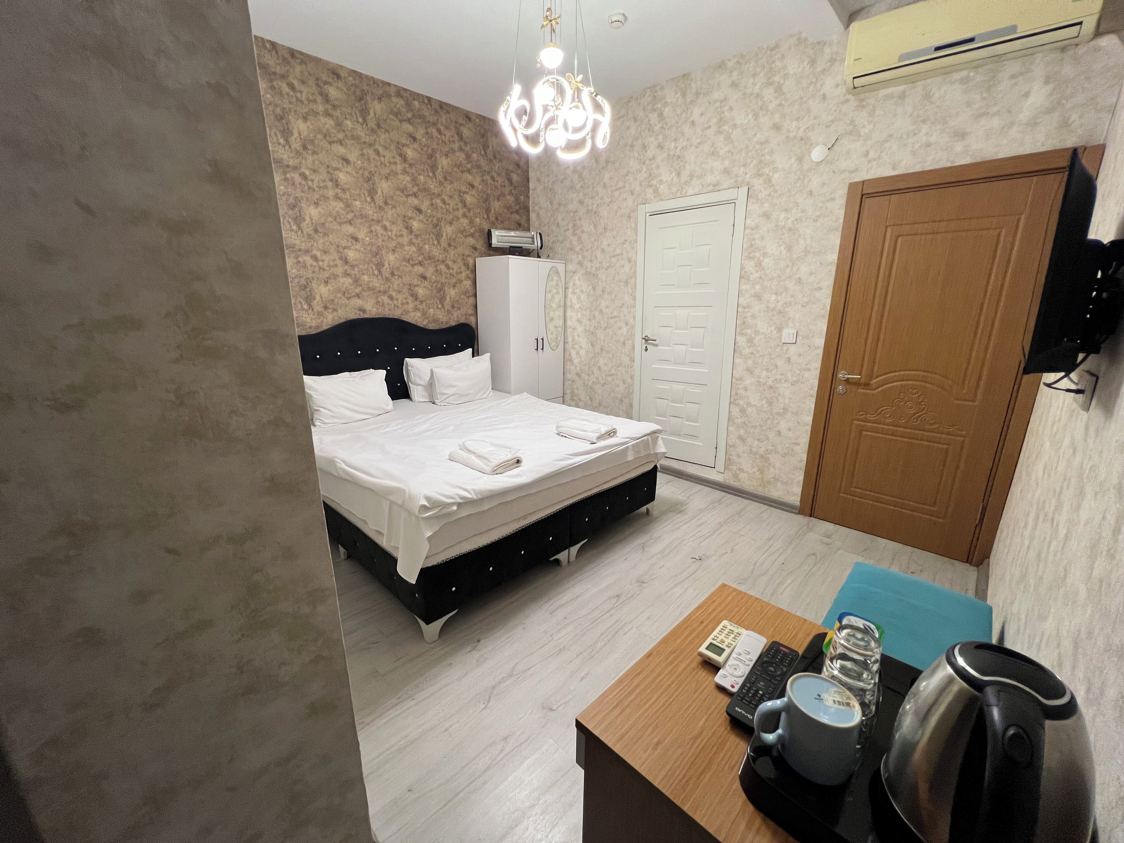 Una camera da letto ordinata con un letto, un comodino e un armadio.