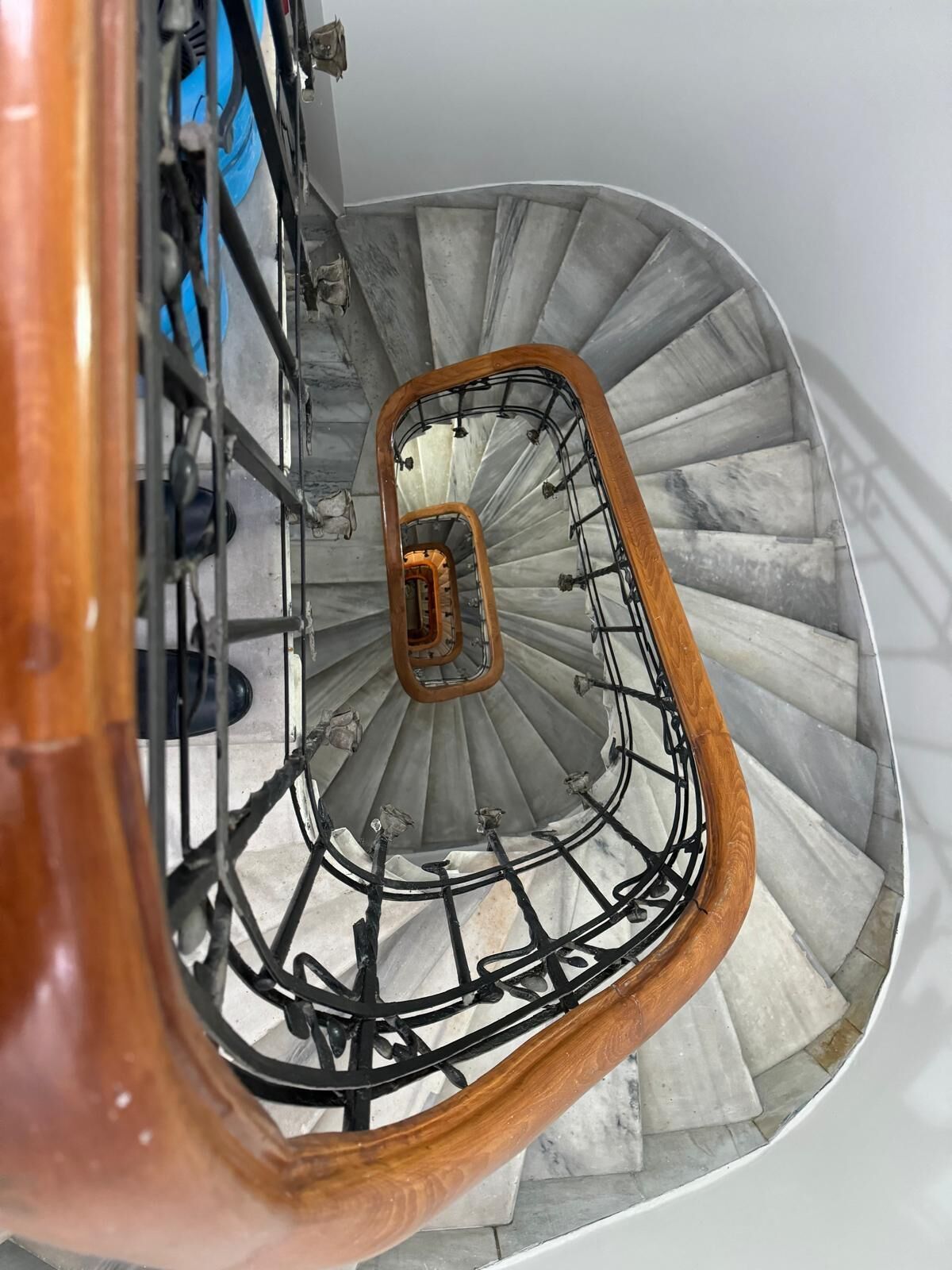 A spiral staircase with a wooden handrail and metal balusters.