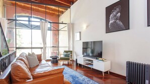A modern living room with a leather sofa, a TV, and a radiator. - Located opposite Bathers Beach it is just a step away from the beach and cafes. Magnificent Rooftop balcony to enjoy the famous WA Sunsets, head out and enjoy a wine in the many bars surrounding the Loft. (Fremantle)