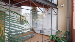 A glass-walled room with a view of a street, a wooden door, and a small garden area with plants. - Located opposite Bathers Beach it is just a step away from the beach and cafes. Magnificent Rooftop balcony to enjoy the famous WA Sunsets, head out and enjoy a wine in the many bars surrounding the Loft. (Fremantle)