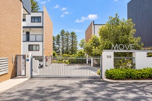 A gated entrance to a residential building with a sign reading 'MOVE' and the number '59' on the gate.